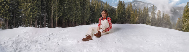 Stivaletti impermeabili EMU Australia da donna in pelle marrone con interno shearling e suola carrarmato, indossati all’aperto.
