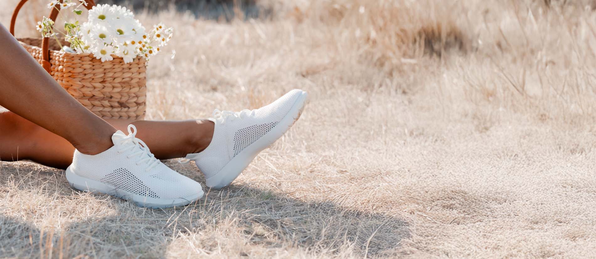 Sneakers donna EMU Australia bianche leggere e traspiranti indossate all’aperto su prato secco