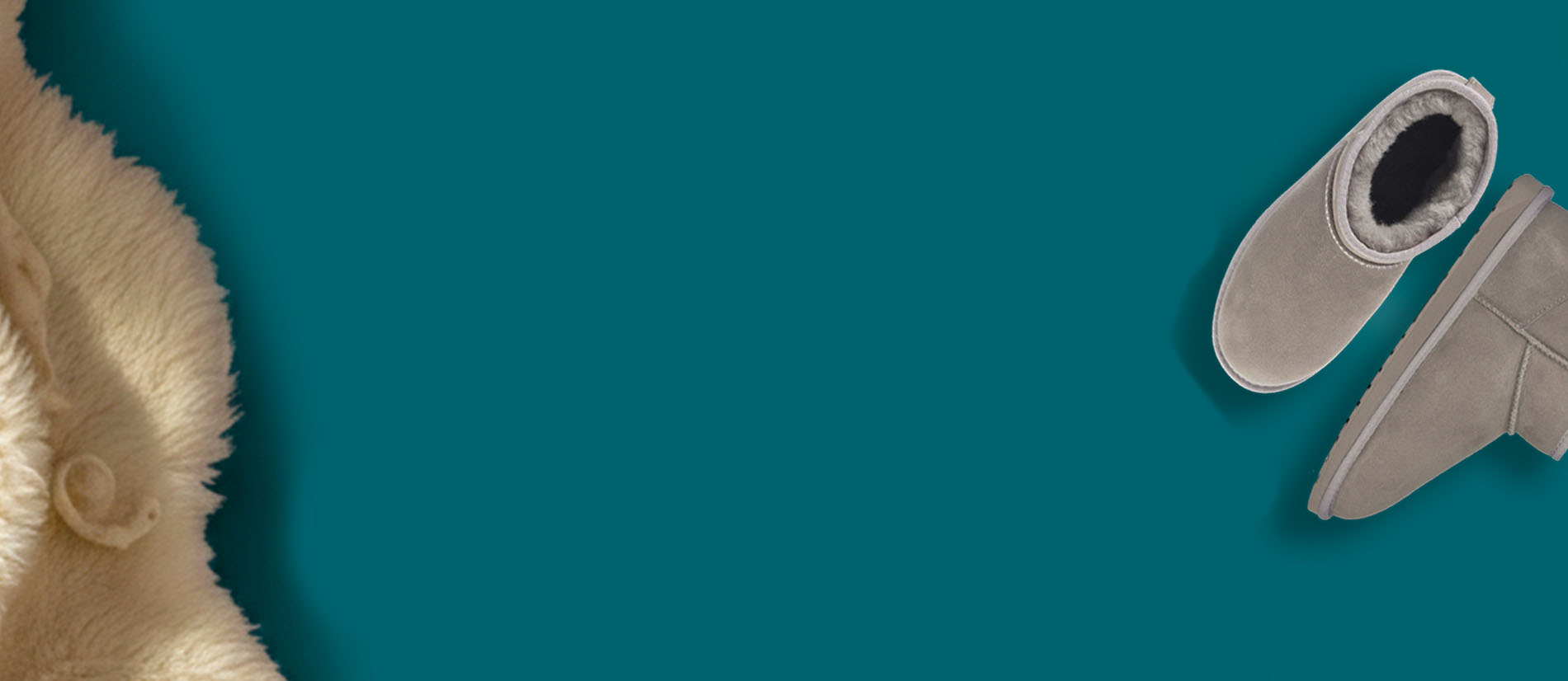 Stivaletti invernali EMU Australia in suede grigio con fodera in pelliccia, appoggiati su sfondo verde petrolio accanto a un morbido tessuto in lana.