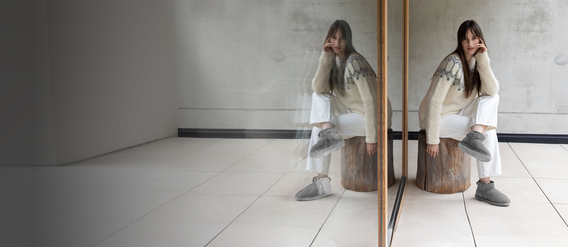 Donna seduta in ambiente minimal che indossa stivaletti EMU da donna in lana naturale, caldi e confortevoli, ideali per l’uso quotidiano indoor e outdoor..