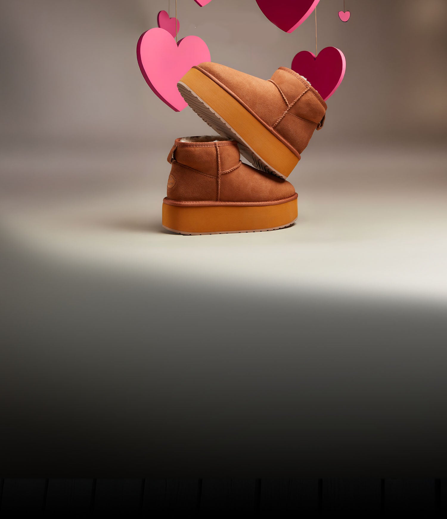 Stivaletti EMU Australia in montone color chestnut con suola flatform, in set studio di San Valentino con cuori sospesi