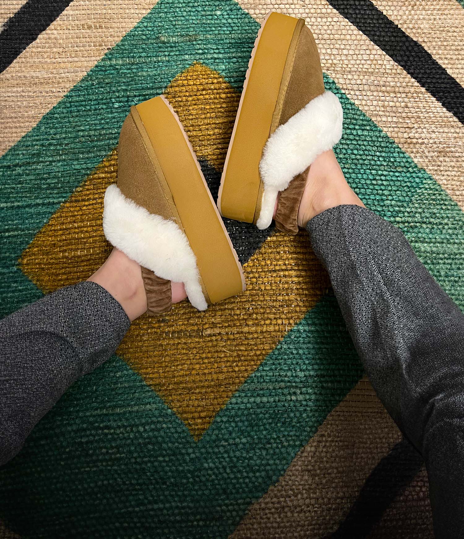 dettaglio_donna_che_indossa_ciabatte_con_pelo_emu_australia_hartz_su_tappeto_colorato