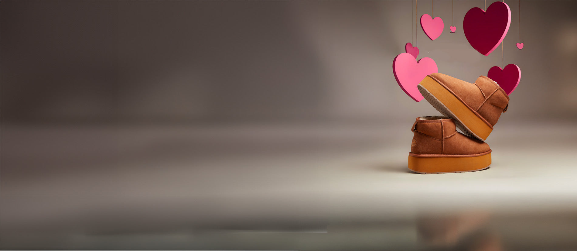 Stivaletti EMU Australia in montone color chestnut con suola flatform, in set studio di San Valentino con cuori sospesi