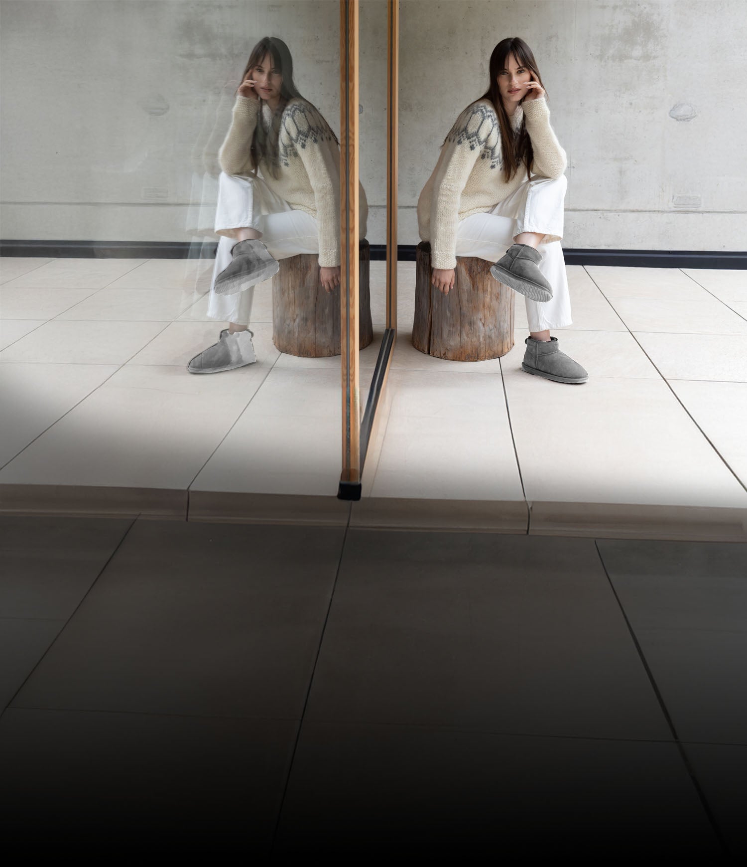 Donna seduta in ambiente minimal che indossa stivaletti EMU da donna in lana naturale, caldi e confortevoli, ideali per l’uso quotidiano indoor e outdoor.