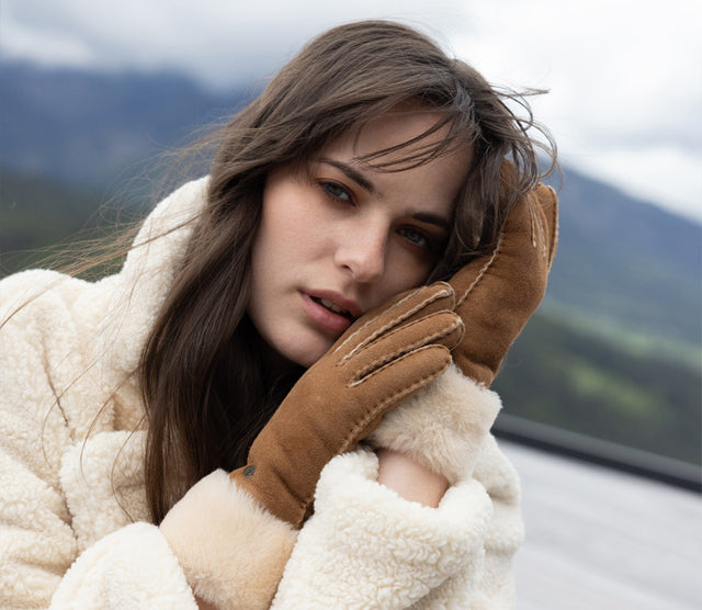 Modella con guanti invernali EMU Australia in pelle scamosciata color cognac e interno in lana, in ambientazione outdoor.