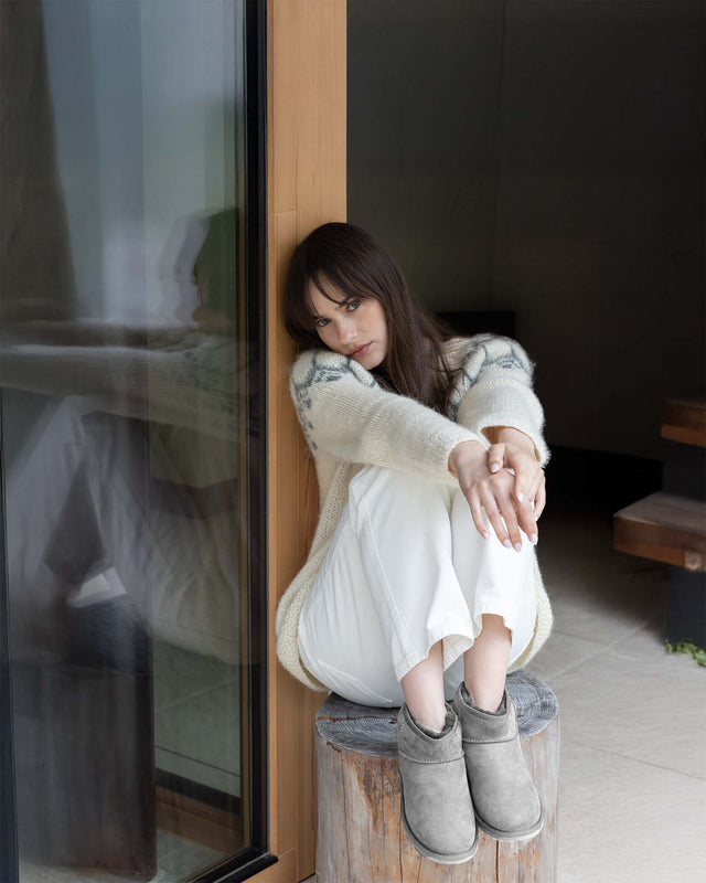 Stivaletti EMU Australia Stinger color grigio esposti su sfondo di montagne innevate, ideali per l’inverno.